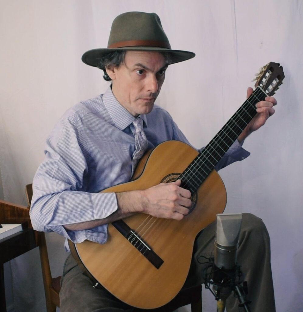 A photo of Stew Gunn playing classical guitar.